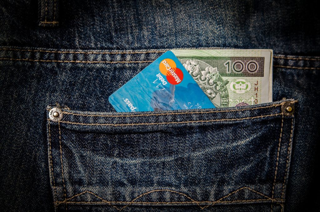 Limity wypłat z bankomatów i płatności gotówką - Karta kredytowa i gotówka w tylnej kieszeni spodni