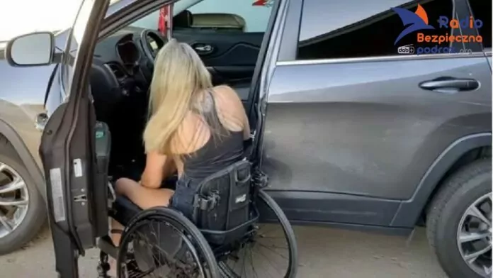 Kierowca niepełnosprawny prawa i obowiązki Na zdjęciu młoda, długowłosa blondynka przesiada się z wózka na miejsce kierowcy w srebrno-szarym samochodzie.