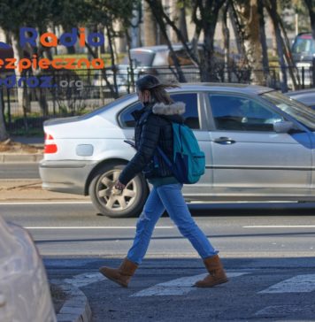 Młoda kobieta na przejściu dla pieszych w mieście. Pieszy - prawa i obowiązki.
