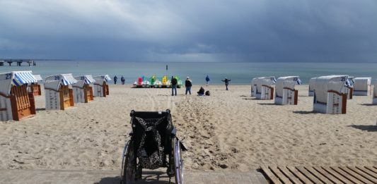 Na zdjęciu wózek inwalidzki na plaży.