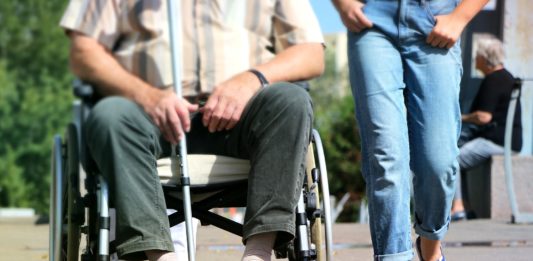 Na obrazku osoba niepełnosprawna z asystentem osób niepełnosprawnych