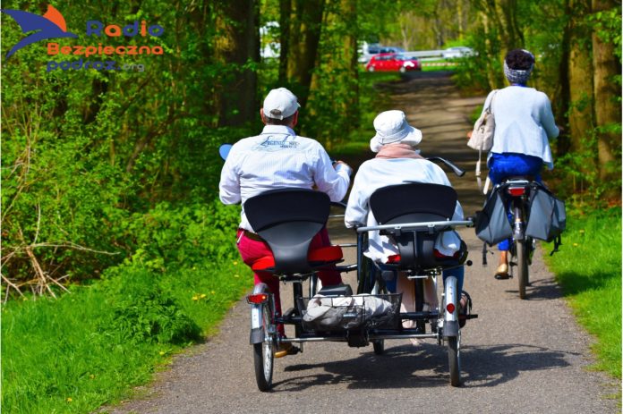 Na zdjęciu trójkołowy rower z wózkiem dla osób z niepełnosprawnosciami. Rowery dla osób niepełnosprawnych.