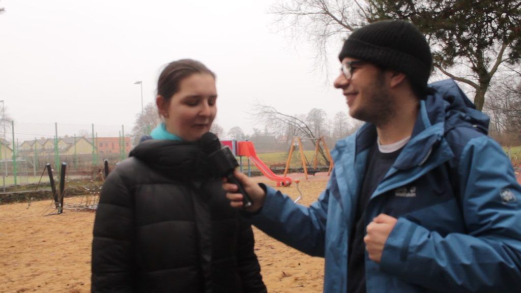 Na zdjęciu dziennikarz przeprowadzający wywiad z młodą kobietą. Kadrowanie zdjęć.
