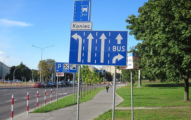 Buspas - Wymysł czy konieczność. Na zdjęciu widoczne znaki informujące o przebiegu buspasa. Po prawej zielony parg, po lewej zatłoczony pas do lewoskrętu.