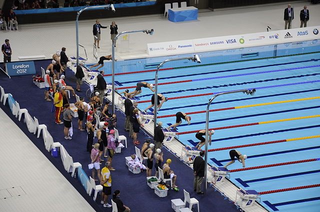 Na zdjęciu niepełnosprawni zawodnicy podczas zawodów pływackich na krytym basenie.