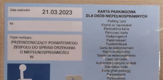 Karta parkingowa dla osób niepełnosprawnych. Dokument po lewej zawiera datę ważności, numer oraz nazwę organu wydającego. Po lewej na dole granatowy symbol osoby niepełnosprawnej oraz hologram. Prawa strona blankietu zawiera napis karta parkingowa w 24 językach unii europejskiej.