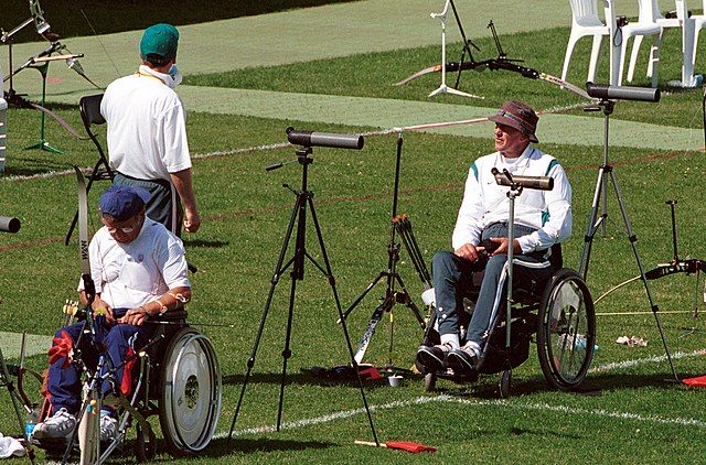 Na zdjęciu zawodnicy na wózkach podczas zawodów. Łucznictwo osób z niepełnosprawnością.