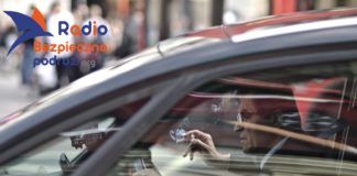 Na zdjęciu kierowca palący papierosa we wnętrzu auta osobowego. Palenie i jedzenie w aucie