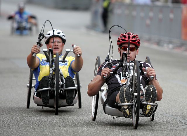 Na zdjęciu zawodnicy na handbiku. Paratriathlon dla osób niepełnosprawnych.