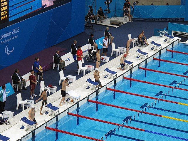 Na zdjęciu niepełnosprawni zawodnicy podczas zawodów pływackich na krytym basenie.  