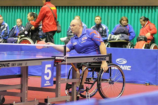 Na zdjęciu mężczyzn na wózku inwalidzkim grający w tenisa stołowego.