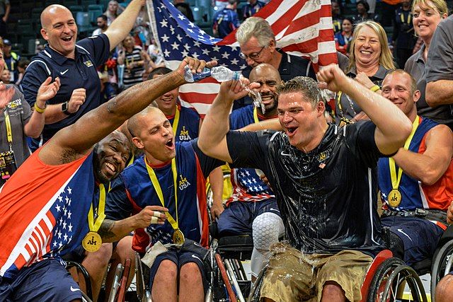Na zdjęciu koszykarze na wózkach z USA i Wielkiej Brytanii świętują po meczu.