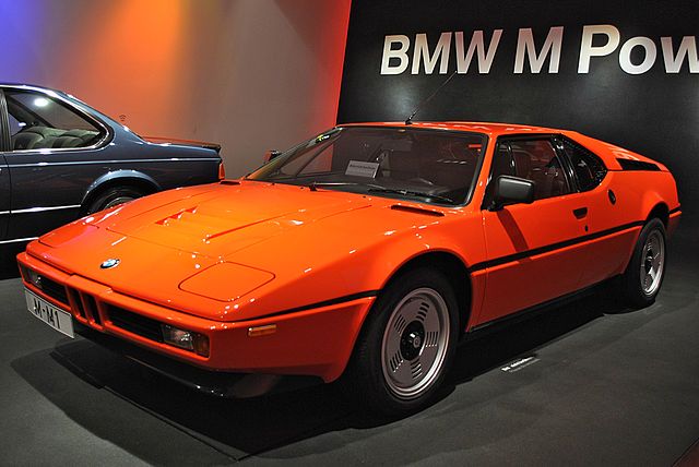 Najgorsze wysokoprężne silniki BMW. Na fotografii , BMW w wersji M1. Wyścigowy model w kolorze siarczystej pomarańczy. Niski, szeroki, bryła zbliżona starszych modeli Lamborghini.