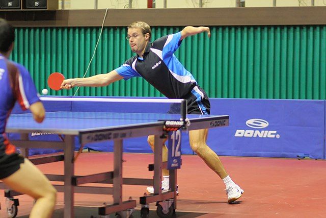Na zdjęciu niepełnosprawni mężczyźni grając w tenisa stołowego. Tenis stołowy dla osób niepełnosprawnych.