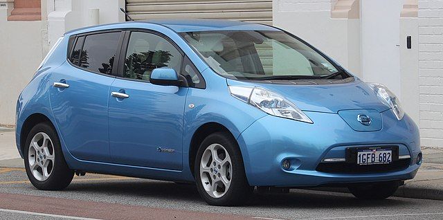 Samochód elektryczny czy hybrydowy. Mały miejski samochód w kształcie kropli wody. Niebieski, perłowy Nissan Leaf ten model zapoczątkował masową produkcję elektryków.