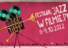 Festiwal JAZZ W FILMIE.PL Poziomy plakat w kolorze różowym, Lewa strona zajęta przez projektor filmowy w którego budowę wpisano trąbkę. Z obiektywu wylewają się słowa informujące o nazwie i terminie festiwalu.