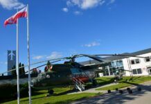 III Ogólnopolski Mityng Modelarski. Przed wejściem do muzeum stoi największy w Polsce śmigłowiec transportowy Mi-6a. w zielonych barwach maskujących.