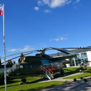 III Ogólnopolski Mityng Modelarski. Przed wejściem do muzeum stoi największy w Polsce śmigłowiec transportowy Mi-6a. w zielonych barwach maskujących.