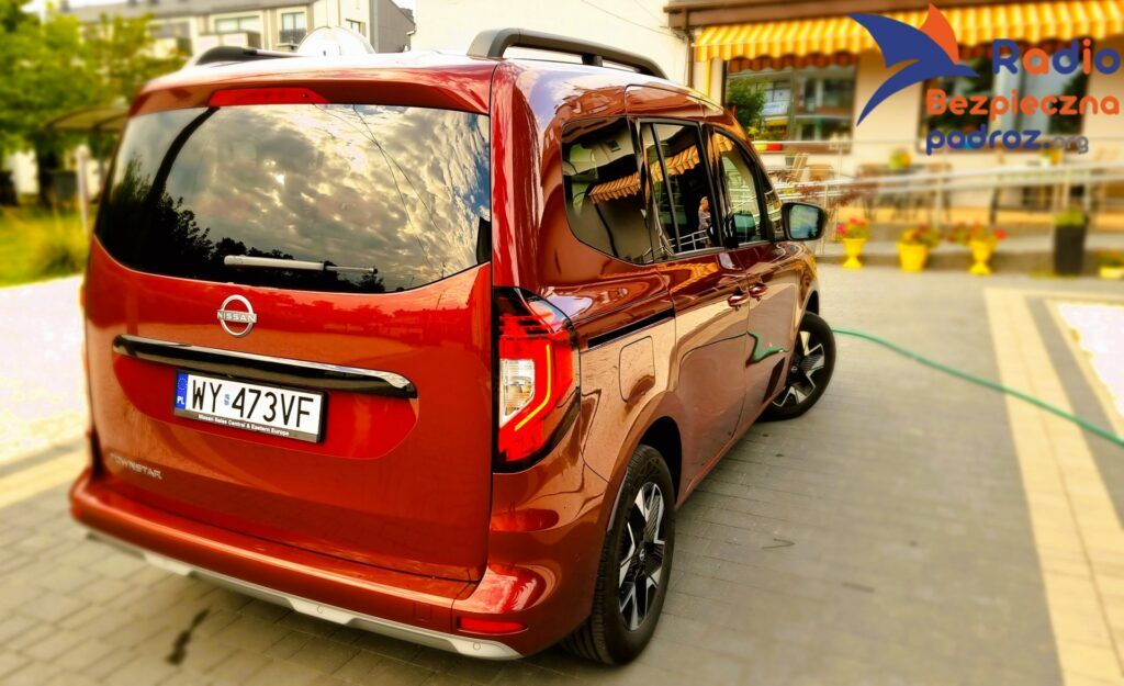 Nissan TownStar Combi profil z tyłu, kolor czerwony na posesji Zdrówko Legionowo