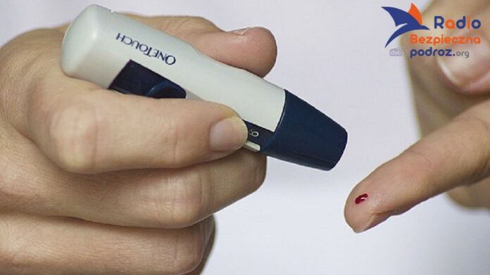 Cukrzyca typu 2 i aktywność fizyczna. Na zdjęciu pomiar poziomu cukru we krwi. Zbliżenie na dłonie, w prawej nakłuwacz. Na palcu wskazującym lewej dłoni widoczna kropla krwi.