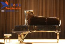 XXVIII Komeda Jazz Festival. Na pustej scenie stoi fortepian wraz ze stołkiem. Widok z profilu, na tle brązowej, pofalowanej kotary.
