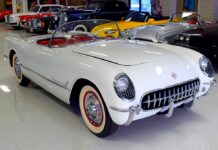 Chevrolet Corvette C1 pierwsza generacja. Na zdjęciu w centrum stoi biały kabriolet Corvette z 1953 roku. W drugim planie wiele innych odrestaurowanych samochodów