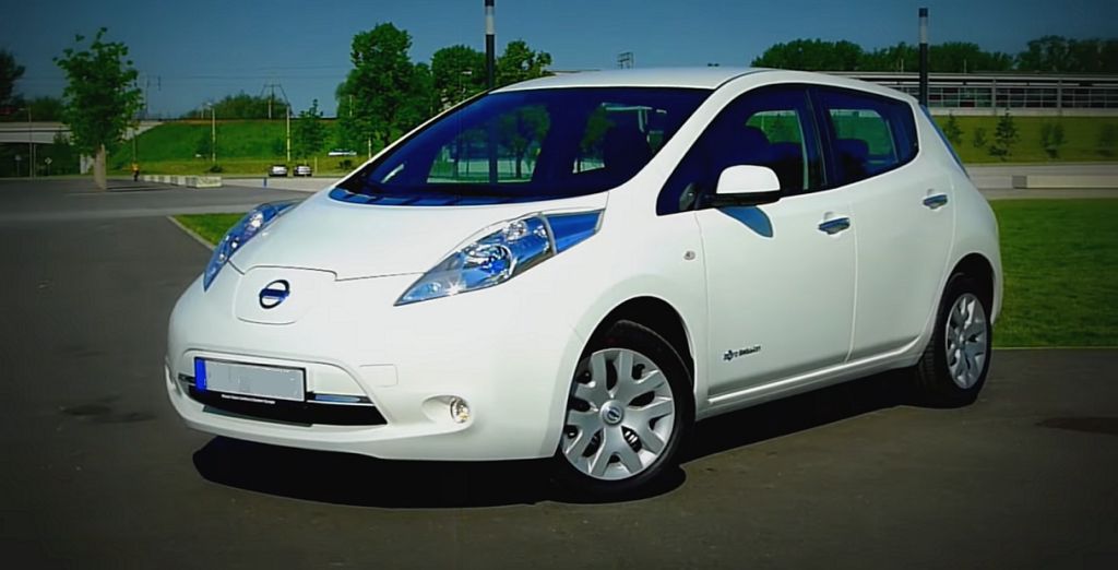 Używany samochód elektryczny - na parkingu stoi biały Nissan Leaf pierwszej generacji