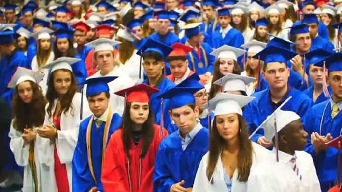 Udogodnienia dla niepełnosprawnych studentów. Amerykańscy studenci podczas promocji ubrani w białe, niebieskie i czerwone togi wraz z biretami.