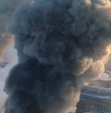 Dlaczego smog jest szkodliwy? Dron wlatujący w obłok dymu z fabrycznego komina. Obok drugi kopcący komin.