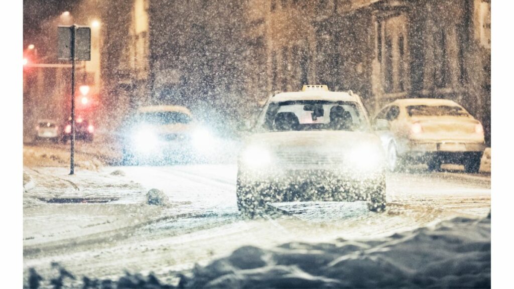  Samochody jadące podczas śnieżycy na drodze