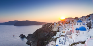 Urlop wypoczynkowy w 2024 roku, piękny widok miasta na greckiej wyspie o zachodzie słońca - wakacje jesienią