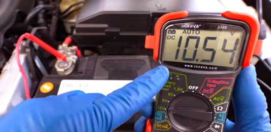Akumulator zimą - na zdjęciu widoczny multimetr mierzący napięcie akumulatora w samochodzie. Wskazuje wartość 10,54 Volta, to dużo za mało.