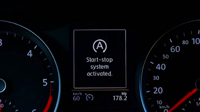 System START - STOP - zbliżenie na wyświetlacz pulpitu Volkswagena. Na czarnym tle widać duży biały napis mówiący, że system start - stop jest aktywny.