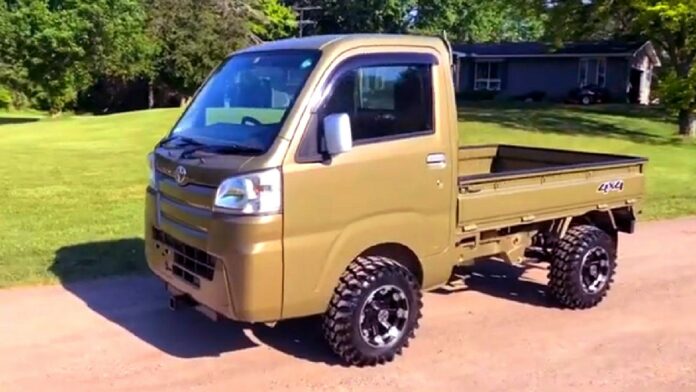 Daihatsu sfałszowane testy zderzeniowe - mini ciężarówka w kolorze oliwkowym, malutka kabina i odkryta skrzynia ładunkowa.