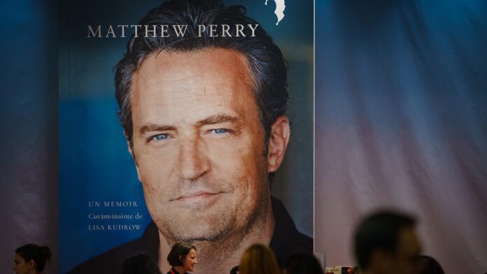 Śmierć Matthew Perry'ego - wielki billboard z okładką autobiograficznej książki z 2022 roku. na okładce uśmiechnięta twarz Matthew.