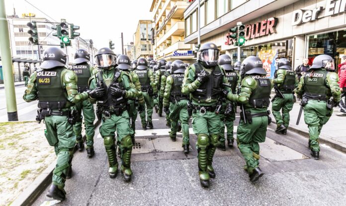 rosnące zagrożenie terrorystyczne w Niemczech, na zdjęciu grupa kilkunastu uzbrojonych antyterrorystów z jednostki specjalnej na miejskiej ulicy
