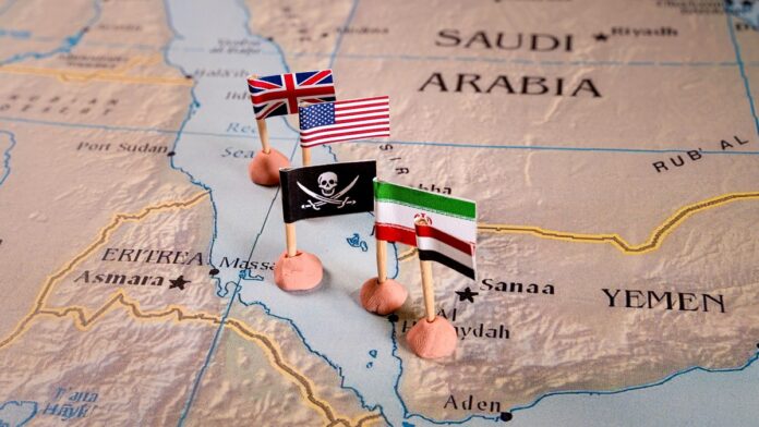 Ataki Houthi - mapka regionu Morza Czerwonego, na niej flagi USA, Wielkiej Brytanii, Iranu otaczające czarną flagę piratów