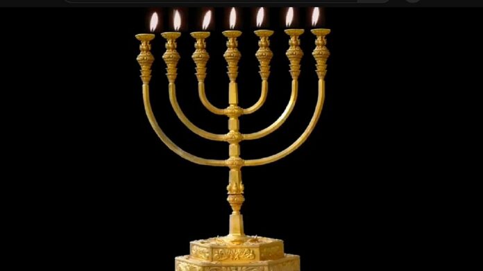 Dzień Pamięci o Ofiarach Holokaustu - na czarnym tle stoi, złoty, zapalony żydowski siedmioramienny świecznik.