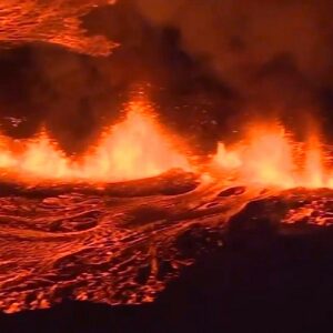 Erupcja wulkanu - płynąca lawa wydobywająca się ze szczeliny w ziemi, całość w odcieniach czerwonych płomieni