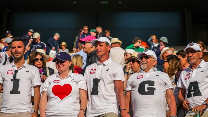 Iga Świątek - tłum kibiców na meczu tenisowym, a w pierwszym rzędzie grupa z Polski w białych T-shirtach. Każdy z nich ma na koszulce jedną literę, a całość układa się w napis 