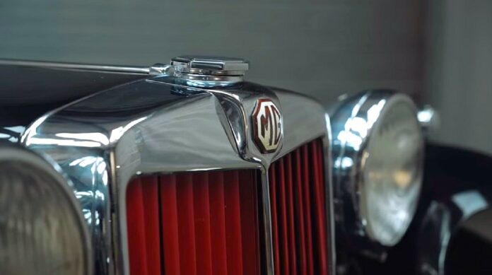 MG Motor- zbliżenie na piękną chromowaną atrapę modelu TB. Na ośmiokątnej białej plakietce, stylizowane litery MG.