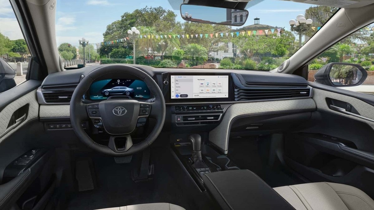 Toyota Camry - widok całego kokpitu z kierownicą, 7 calowymi wskaźnikami cyfrowymi oraz ponad 12 calowym wyświetlaczem multimediów.