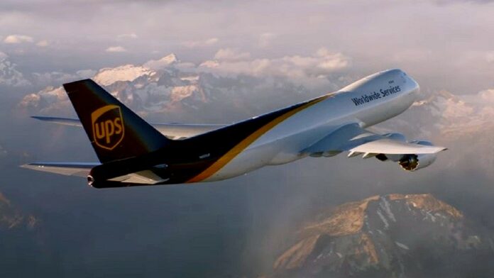UPS zwolni 12 000 pracowników - Boeing w biało-brązowo-złotych barwach UPS leci wysoko ponad górami.