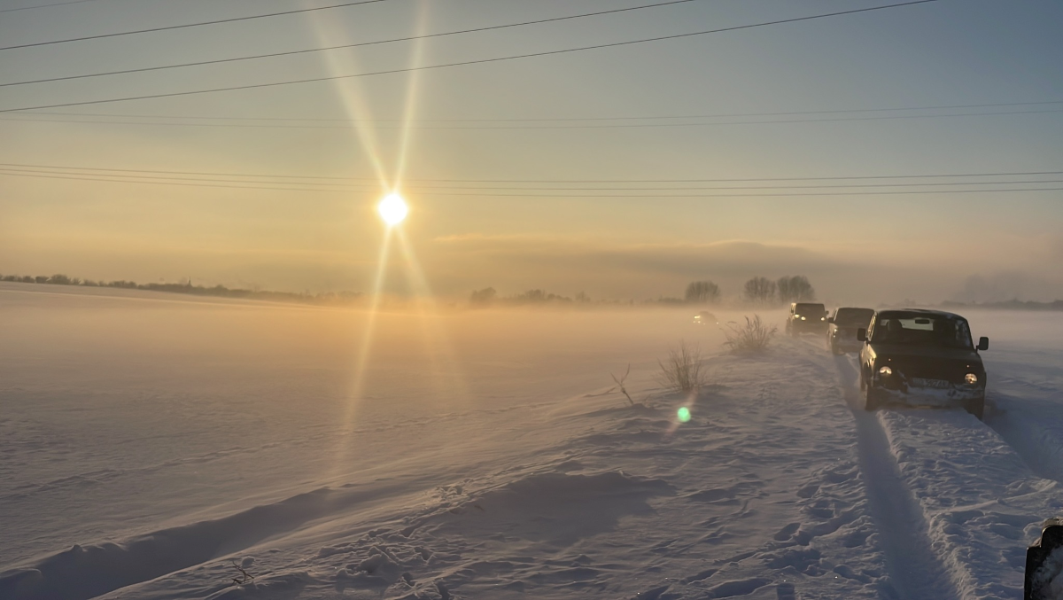 Zimowa Jura z Ekipa Piaskownica 4x4 2024 odbędzie się w zimowych warunkach, zimowy krajobraz na tle zachodzącego słońca i kolumna aut. organizator Ekipa Piaskownica 4x4