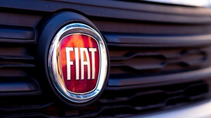 Likwidacja fabryki - zbliżenie na czarną atrapę samochodu, na niej czerwone kółko, a w nim biały napis FIAT