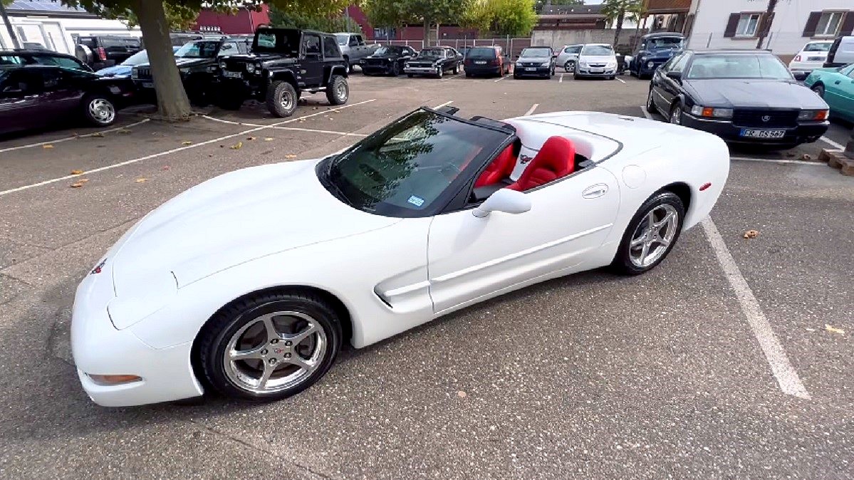 Chevrolet Corvette C5 - piękny biały kabriolet ze złożonym dachem, wnętrze wykonane z czerwonej skóry.