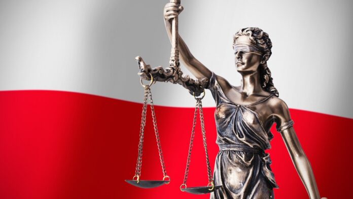 Zaostrzenie kar dla gwałcicieli - metalowa figurka Temidy, trzymającej w wyciągniętej prawej ręce wagę, stoi na tle biało-czerwonych barw Polski.