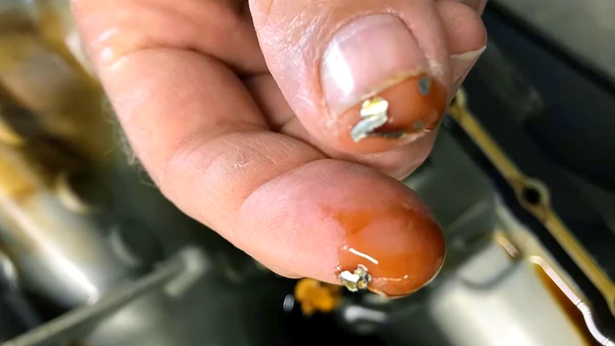 łańcuch rozrządu - na palcach dłoni widać opiłki metalu w oleju silnikowym