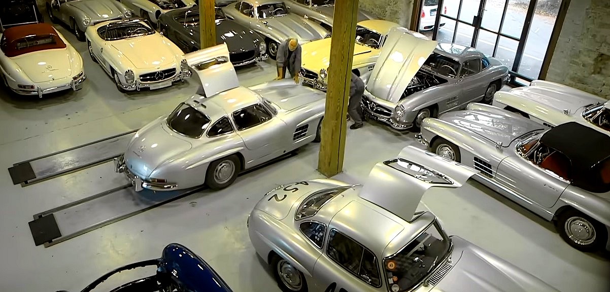 podróbki zabytkowych samochodów - widok garażu z wieloma egzemplarzami zabytkowych mercedesów, większość to sportowe modele w srebrnym kolorze.