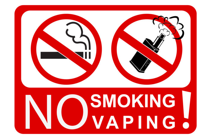 zakaz sprzedaży e-papierosów jednorazowych, biało-czerwona tablica z napisem NO SMOKING - NO VAPING oraz obrazkowymi zakazami palenia tytoniu i e-papierosów